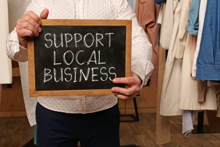 Support local business is shown using a text on a board held by a businessman
