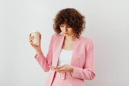 accountant texting while holding a coffee
